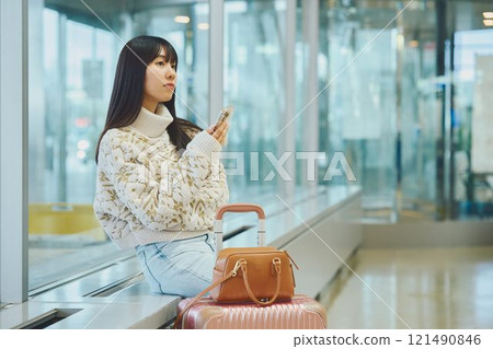 A woman in an airport lobby about to embark on a solo trip 121490846