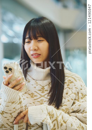 一個女人看著她的智慧型手機,做出厭惡的表情 一個女人看著她的智慧型手機,做出厭惡的表情 121490847