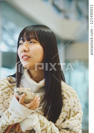A woman looking at her smartphone and making a disgusted face 121490851