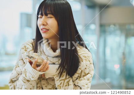 A woman looking at her smartphone and making a disgusted face 121490852