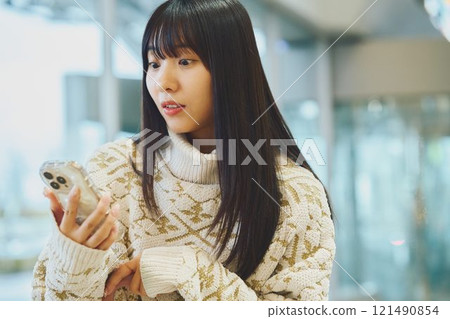 一個女人驚訝地看到一部智能手機 一個女人驚訝地看到一部智能手機 121490854