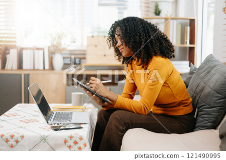 Young woman relax on comfortable couch at home texting messaging on smartphone and tablet Young woman relax on comfortable couch at home texting messaging on smartphone and tablet 121490995