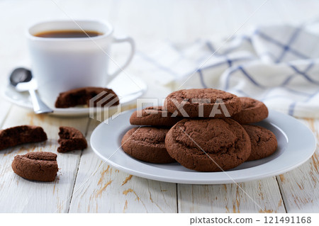 Tasty chocolate cookies and coffee on a white table, selective focus. Tasty chocolate cookies and coffee on a white table, selective focus. 121491168