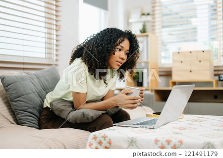 Young woman using a tablet in a cozy home, capturing creativity, relaxation, and digital connection 121491179