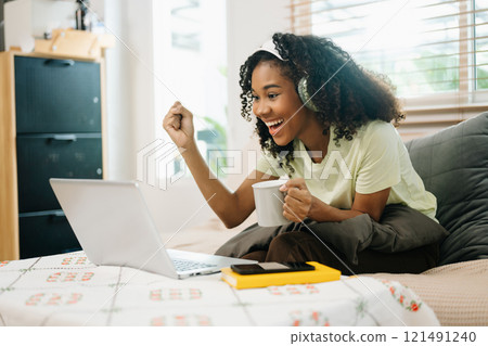 Young woman using a tablet in a cozy home, capturing creativity, relaxation, and digital connection 121491240