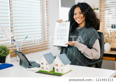 Young real estate agent worker working with laptop and tablet at table in office Young real estate agent worker working with laptop and tablet at table in office 121491313