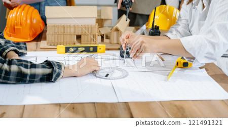 Creative architect projecting on the big drawings with architectural project at construction site 121491321