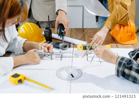 Engineer teams meeting working together wear worker helmets hardhat on construction site 121491323
