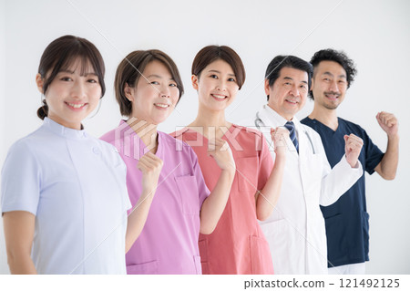 照片中，醫生和護士並肩站立，揮舞著拳頭，看著鏡頭，見證他們職業轉變的成功。 121492125