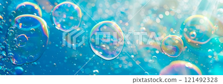 blue background with detergent foam bubbles floating and popping, surrounded by colorful, swirling soap suds. 121492328