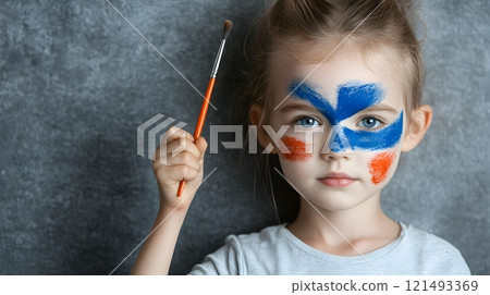 A child painting an Australian flag on their face, celebrating Australia Day 121493369