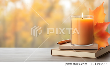 Warm desk setup with a notebook, pen, and candle, cozy evening ambiance 121493556