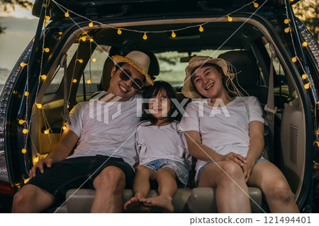 Asian family sitting backseat in car on beach at sunset, funny in holidays and relaxation together. Dad, mom and daughter happy weekend travel enjoy at beach. summer vacation travel camping road trip Asian family sitting backseat in car on beach at sunset, funny in holidays and relaxation together. Dad, mom and daughter happy weekend travel enjoy at beach. summer vacation travel camping road trip 121494401