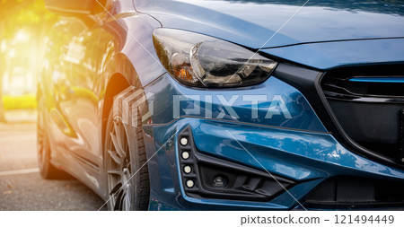 Blue modern car xenon headlight lamp. Shiny chrome design safety technology for night driving. Clean reflective and stylish sedan headlight in the industry. Detail on one of the LED car headlights 121494449