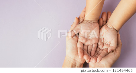 Celebrating family day, Parents and kid holding empty hands together on a color background. Space for text. 121494465