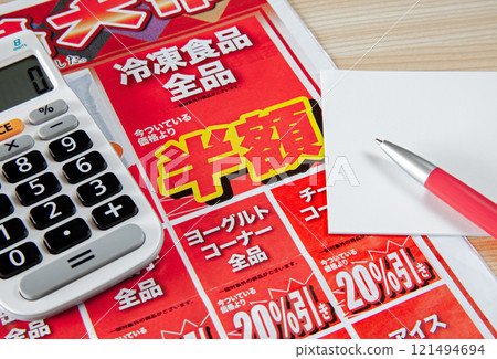 Image of taking note of special offers while looking at a newspaper insert flyer 121494694