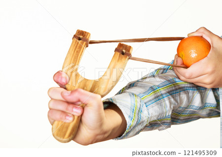 Kid holding slingshot in hands Kid holding slingshot in hands 121495309