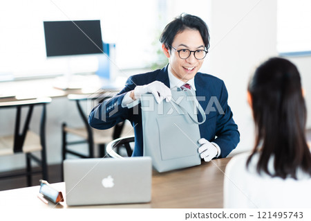 A buyer and a housewife assessing a bag 121495743