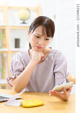 Woman, middle-aged, bankbook, worries 121496221