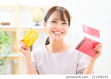 Middle-aged woman happy holding her wallet and bankbook 121496245