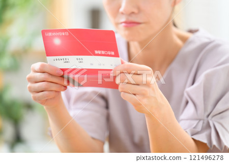 Middle-aged woman, bankbook, worries, hand 121496278