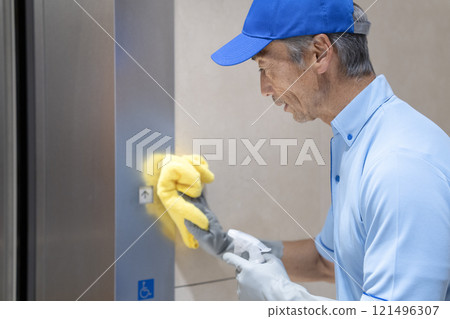 大樓清潔形象：高級男性清潔工擦拭電梯按鈕 121496307