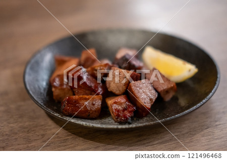 Grilled beef tongue served on plate with lemon Grilled beef tongue served on plate with lemon 121496468