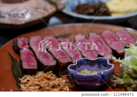Medium rare sliced rib eye meat served on plate with vegetable 121496471