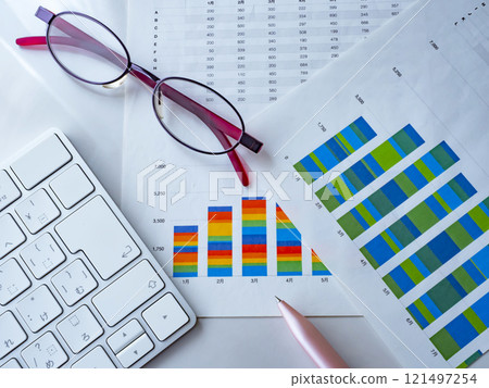 Graph, keyboard and glasses on a table 121497254