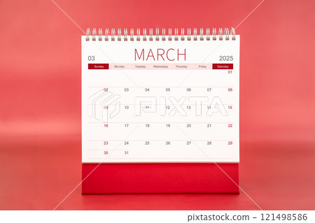 March 2025 blank desk calendar on red color background. 121498586