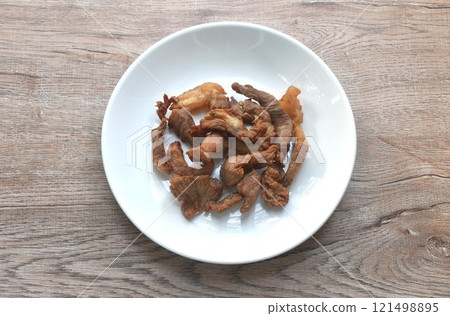 fried crispy salty fermenting beef meat with pandan and herb on plate  121498895