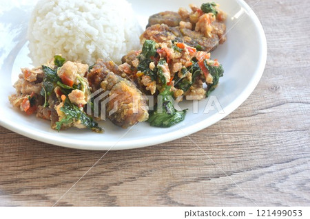 slice boiled black preserved egg dressing spicy fried chop pork meat and basil leaf on plain rice in plate slice boiled black preserved egg dressing spicy fried chop pork meat and basil leaf on plain rice in plate 121499053