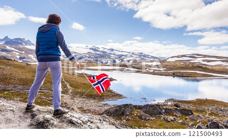 Tourist with norwegian flag in mountains 121500493