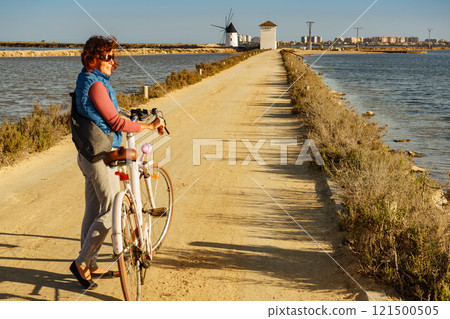 Woman with bike at San Pedro del Pinatar park, Spain Woman with bike at San Pedro del Pinatar park, Spain 121500505