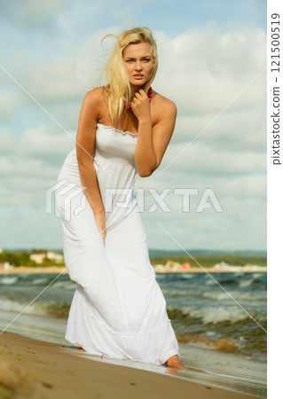 Beautiful blonde girl on beach, summertime 121500519