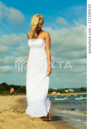 Female tourist walking on beach. 121500520