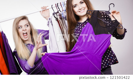 Woman picking clothes in wardrobe, friend being jealous Woman picking clothes in wardrobe, friend being jealous 121501422