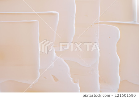 Swatch with white cream texture on a beige background. 121501590