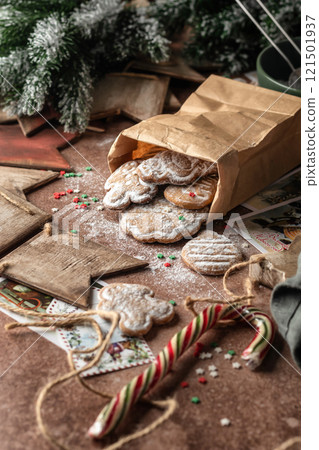 Christmas gingerbread cookies in kraft paper bag on rustic table with fir branches, spices, christmas decorations. Xmas homemade gifts, atmospheric holiday Christmas gingerbread cookies in kraft paper bag on rustic table with fir branches, spices, christmas decorations. Xmas homemade gifts, atmospheric holiday 121501937