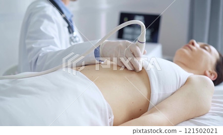 Doctor man, wearing white medical gloves, is using ultrasound equipment on the breast of a female patient lying down for a medical cardiology examination. Medicine concept Doctor man, wearing white medical gloves, is using ultrasound equipment on the breast of a female patient lying down for a medical cardiology examination. Medicine concept 121502021
