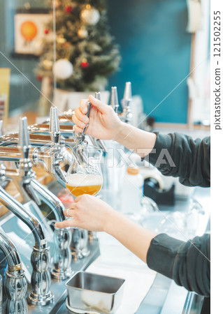 A female clerk pouring beer from a dispenser. Photo courtesy of Tsukioka Brewery. 121502255