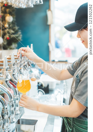 A female clerk pouring beer from a dispenser. Photo courtesy of Tsukioka Brewery. A female clerk pouring beer from a dispenser. Photo courtesy of Tsukioka Brewery. 121502262