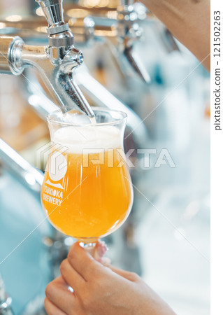 A female clerk pouring beer from a dispenser. Photo courtesy of Tsukioka Brewery. A female clerk pouring beer from a dispenser. Photo courtesy of Tsukioka Brewery. 121502263