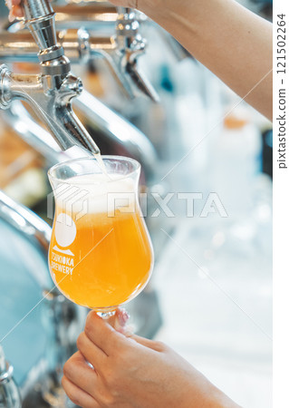 A female clerk pouring beer from a dispenser. Photo courtesy of Tsukioka Brewery. A female clerk pouring beer from a dispenser. Photo courtesy of Tsukioka Brewery. 121502264