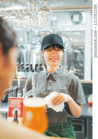 A young woman communicating with a store clerk. Photo courtesy of Tsukioka Brewery. A young woman communicating with a store clerk. Photo courtesy of Tsukioka Brewery. 121502286