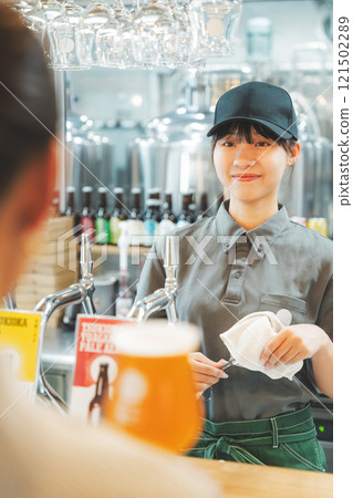 一名年輕女子與店員交談 照片由月岡啤酒廠提供。 121502289
