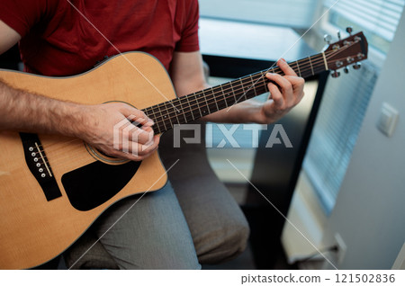 Guitarist on acoustic guitar playing melody. Close up musician instrument with pick in hand Guitarist on acoustic guitar playing melody. Close up musician instrument with pick in hand 121502836