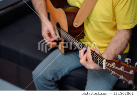 Guitarist on acoustic guitar playing melody in studio. Close up musician instrument 121502861