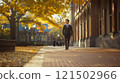 Wide angle view of Asian professor walking towards camera in university campus with autumn trees and classic architecture copy space 121502966