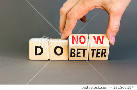 Do better and now symbol. Concept words Do better Do now on wooden block. Beautiful grey table grey background. Businessman hand. Business do better and now concept. Copy space. 121503194